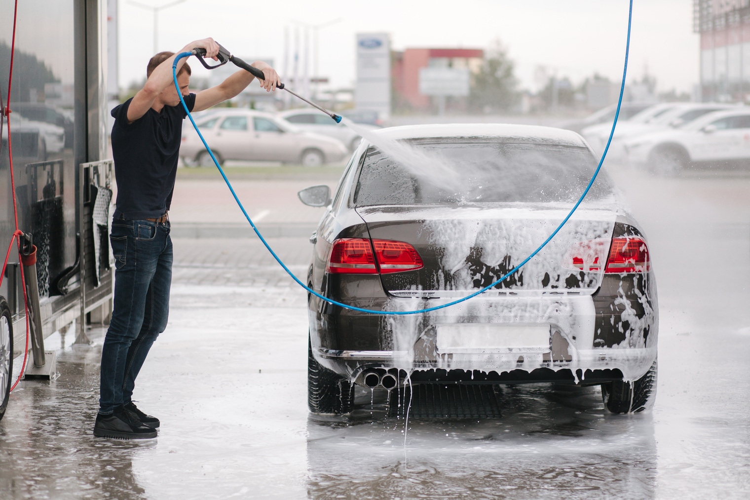 Man Cleaning Car with Pressure Washer